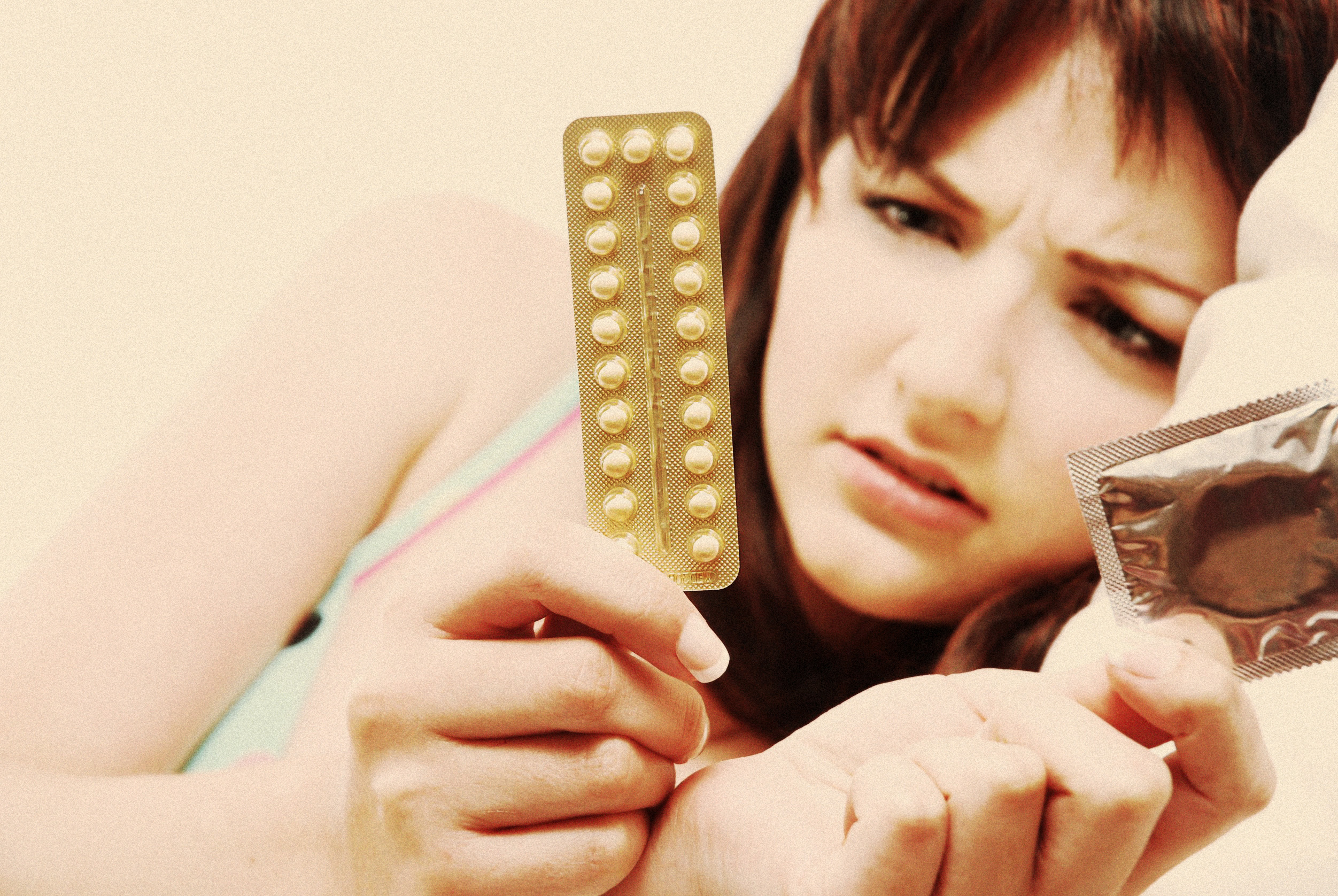 A young girl is trying to decide between The Pill and a condom
