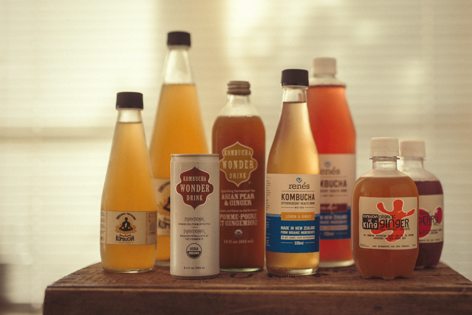 An array of different brands of Kombucha sit on a box