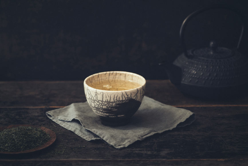 A single cup of Green Tea sits on a cloth napkin to indicate that antioxidants are important