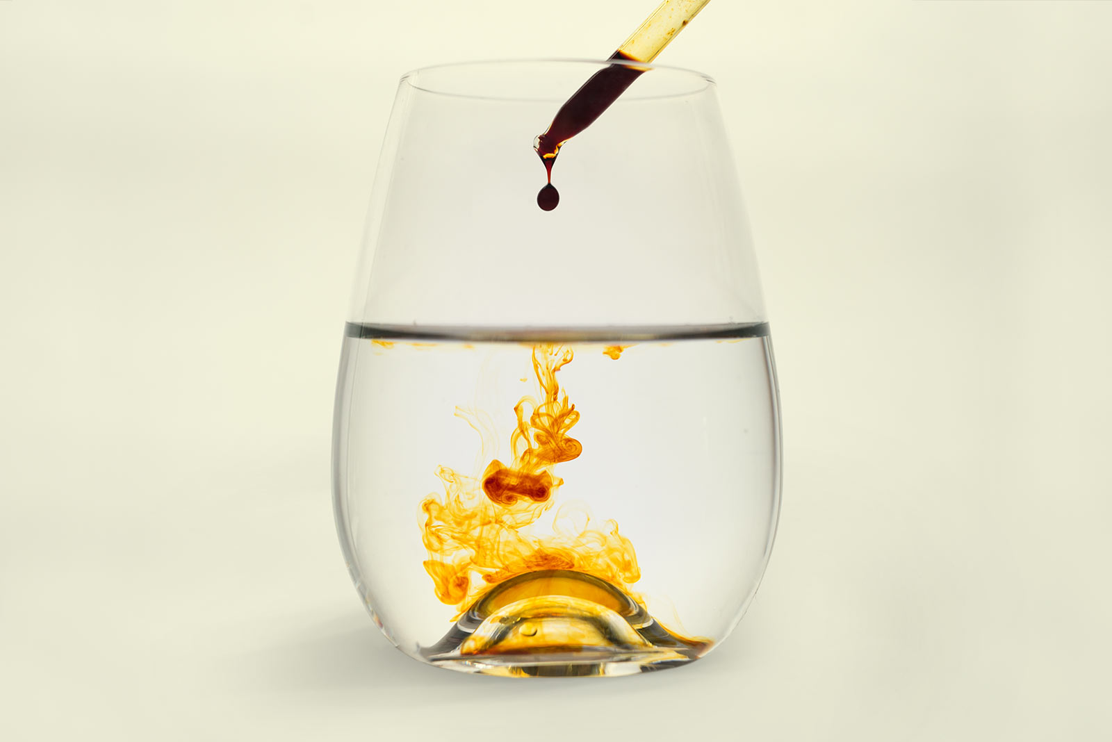 Iodine solution being dropped into a wine glass of water