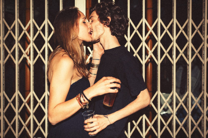 A young couple drinking hard liquor kiss passionately as it enhances the libido in moderation