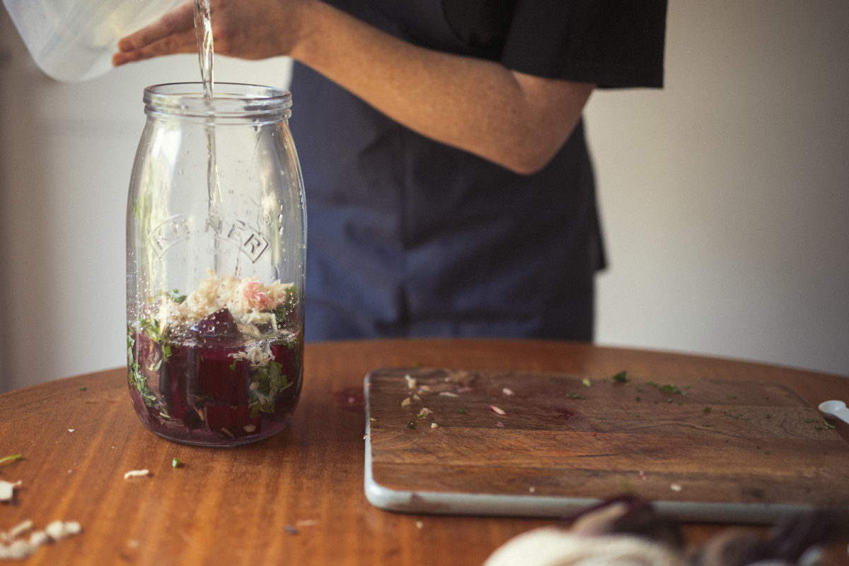 Naturopath Lisa Fitzgibbon fills a large jar with the ingredients for making beetroot Kvass