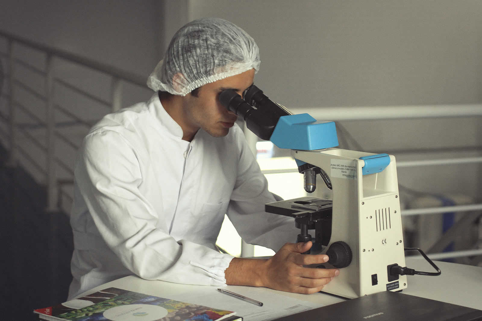 As part of functional testing a male lab technician looks through his microscope