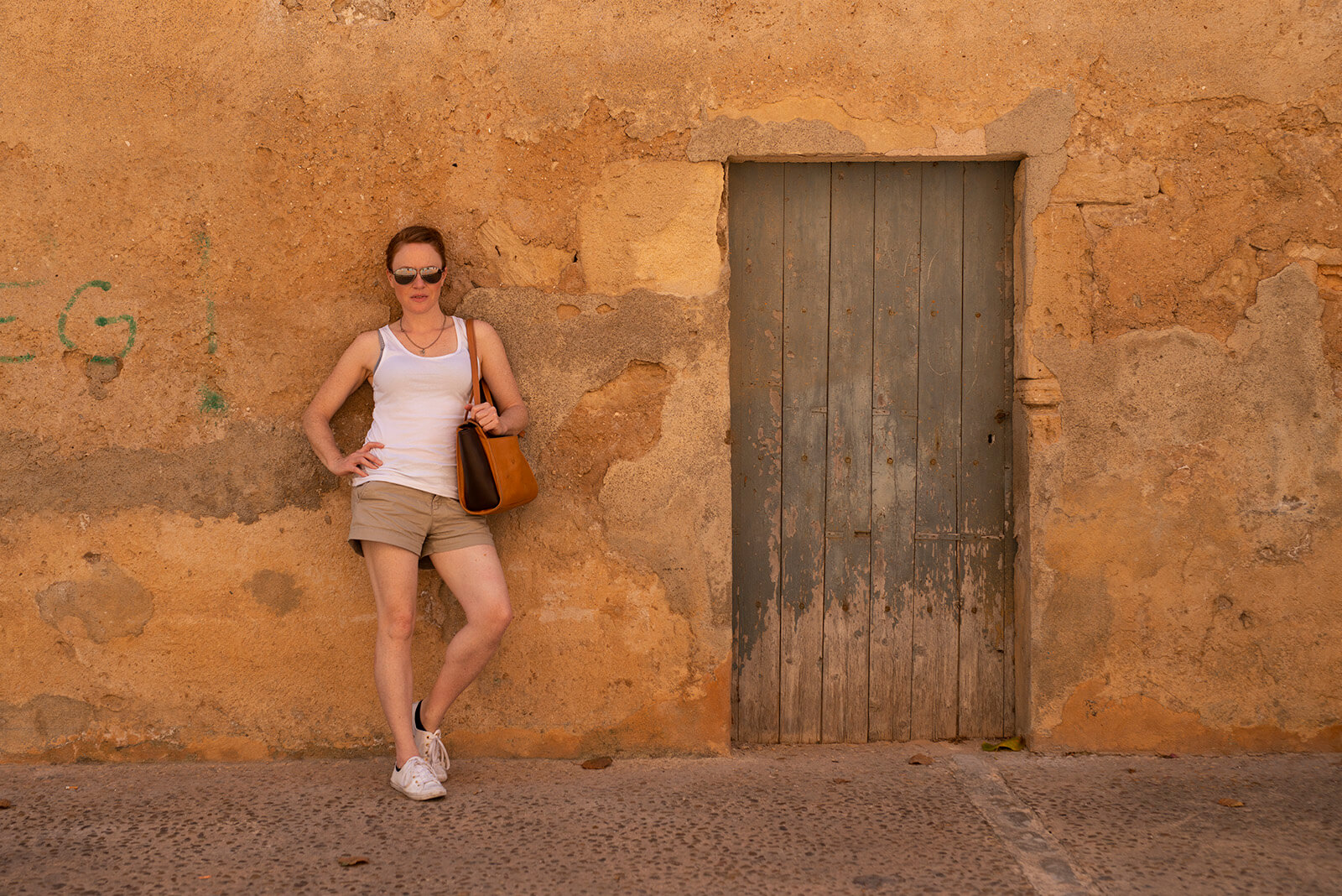 Naturopath, Lisa Fitzgibbon, looking sassy and leaning on a brick wall in Mallorca