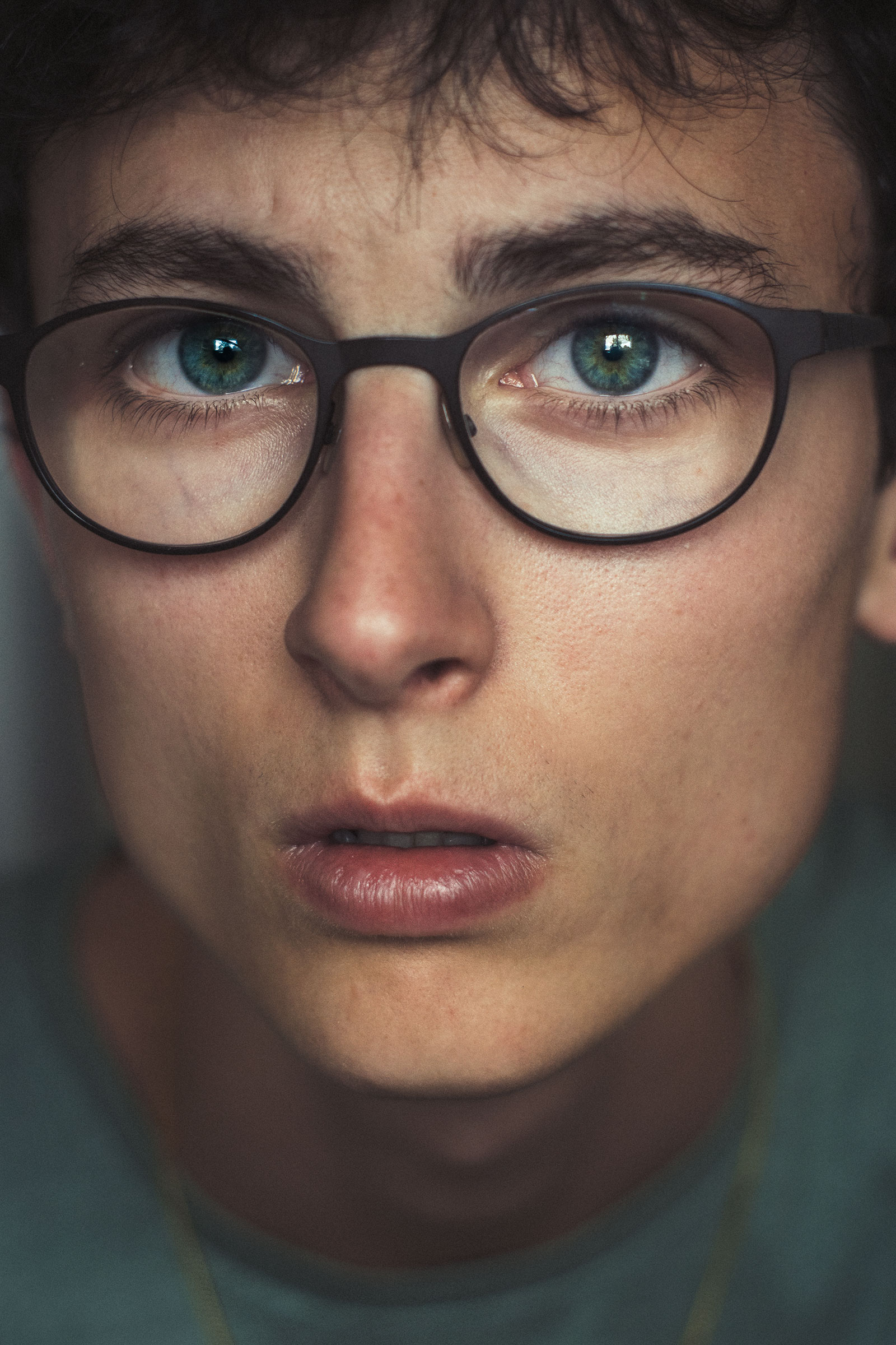 Androgynous person wearing reading glasses has healthy limbal rings of the eyes