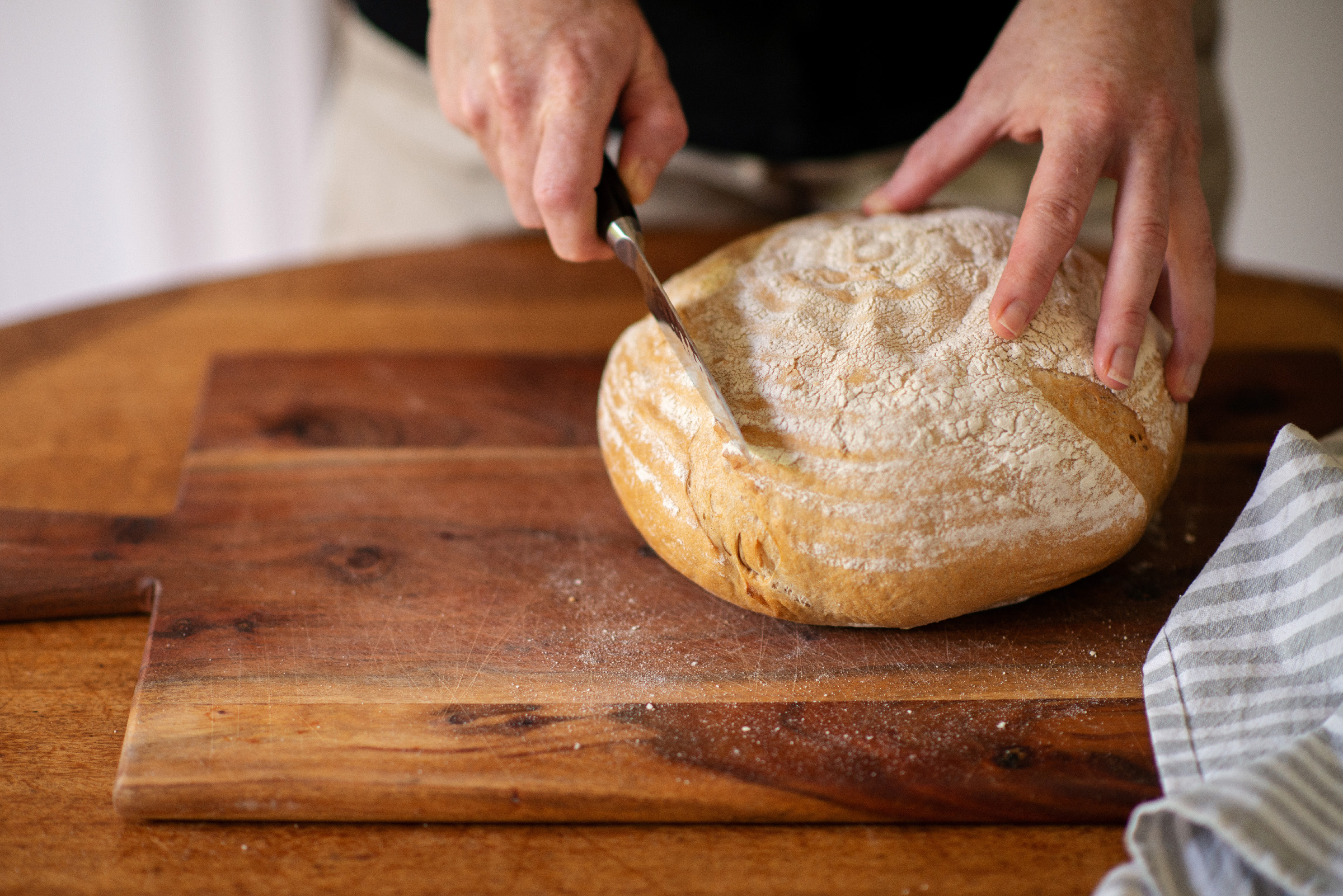 San Francisco Sourdough bread is being cut on a chopping board by Naturopath Lisa Fitzgibbon